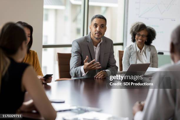 mid adult businessman facilitates meeting - boardmember stock pictures, royalty-free photos & images