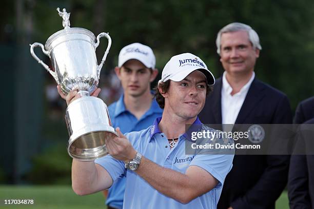 Rory McIlroy of Northern Ireland poses with the trophy after his eight-stroke victory on the 18th green to win during the 111th U.S. Open at...