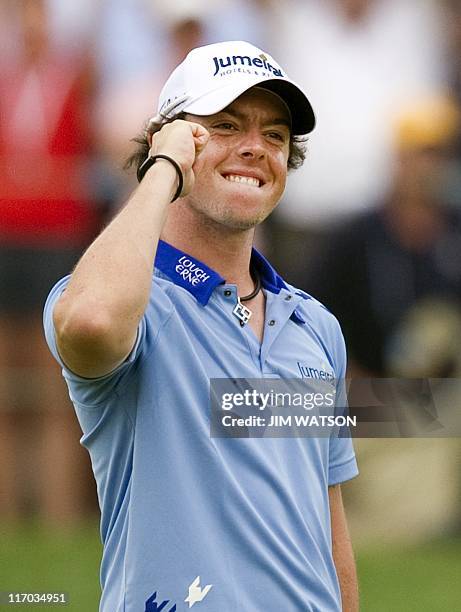 Rory McIlroy of Northern Ireland celebrates after sinking his final putt and winning the 111th US Open by eight strokes over Jason Day with a record...