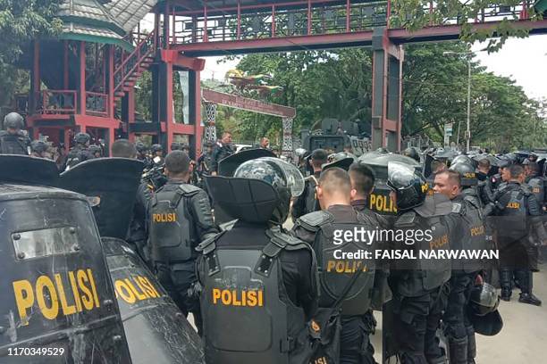 Indonesian riot police take positions at a university in provincial capital Jayapura on September 23 as fresh protests break out in the restive...