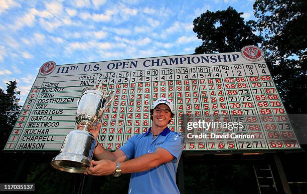 Rory McIlroy of Northern Ireland poses with the trophy after his eight-stroke victory on the 18th green during the 111th U.S. Open at Congressional...