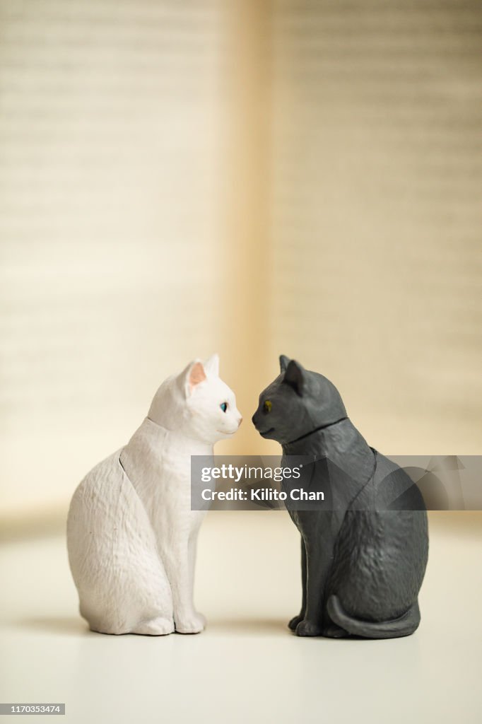Two cat figurines facing each other