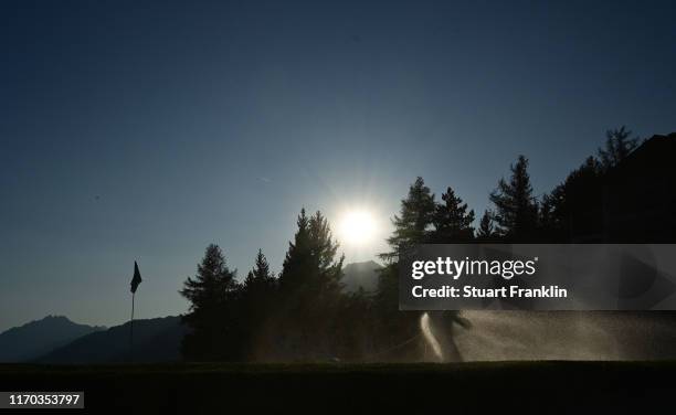 Green keeper waters the eighth green prior to the start of the Omega European Masters at Crans Montana Golf Club on August 26, 2019 in Crans-Montana,...