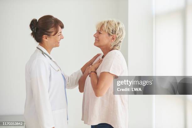 female doctor delivering good news to mature female patient. - patient good news stock pictures, royalty-free photos & images