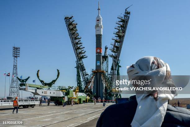 United Arab Emirates' journalist looks on as the Soyuz booster rocket FG with Soyuz MS-15 spacecraft is mounted on the launch pad at the...