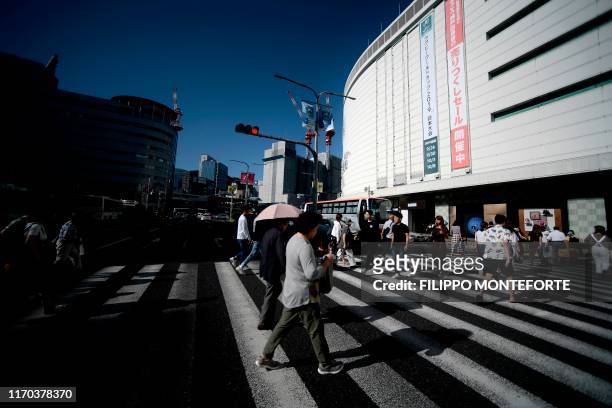 People cross a street in the center of Kobe on September 23, 2019. - The Japan 2019 Rugby World Cup is taking place in Japan from September 20, 2019...