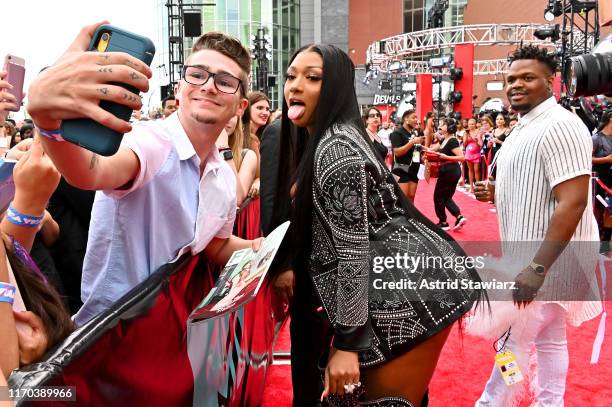 Megan Thee Stallion poses for a selfie with a fan during the 2019 MTV Video Music Awards at Prudential Center on August 26, 2019 in Newark, New...