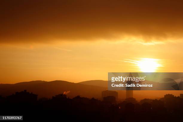 smoky cityscape image over orange color sunset sky - dramatic weather over istanbul stock pictures, royalty-free photos & images
