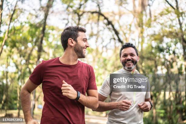 amici che corrono insieme in un parco - guys hanging out foto e immagini stock