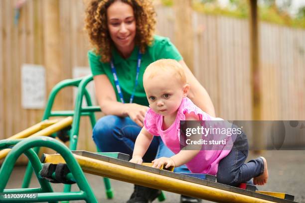 baby on climbing frame - nursery school child stock pictures, royalty-free photos & images