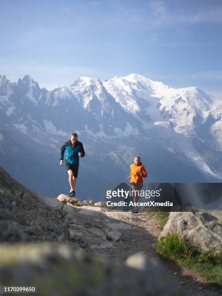 couple trail run through mountains in morning light - great effort stock pictures, royalty-free photos & images