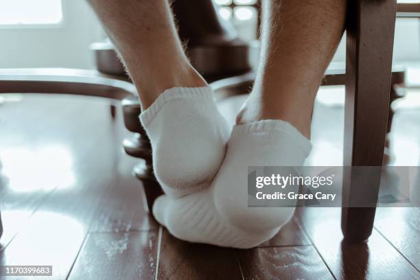 close-up of man's feet at kitchen table - men in white socks 個照片及圖片檔