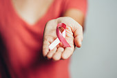 Healthcare and medicine concept - woman holding pink breast cancer awareness ribbon