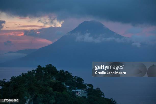 Houses stand on a hillside overlooking the scenic volcano-ringed Lake Atitlan on August 24, 2019 in Solola, Guatemala. Many homes in Guatemala, known...
