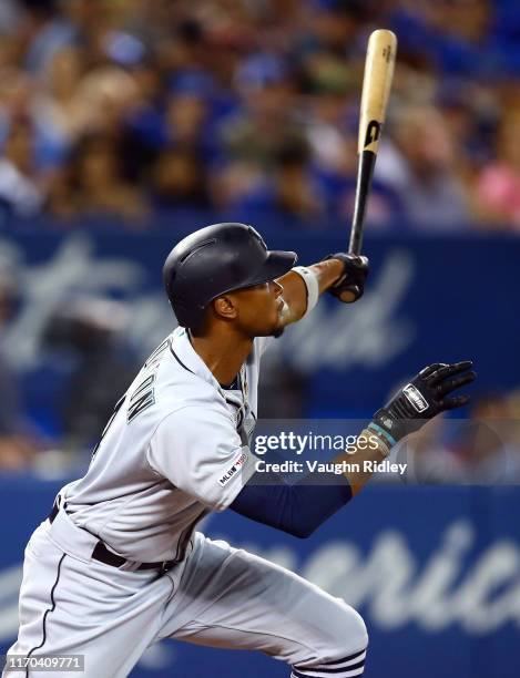 Keon Broxton of the Seattle Mariners hits a sacrifice fly as Austin Nola scores a run in the second inning during a MLB game against the Toronto Blue...