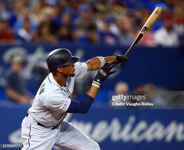Keon Broxton of the Seattle Mariners hits a sacrifice fly as Austin Nola scores a run in the second inning during a MLB game against the Toronto Blue...