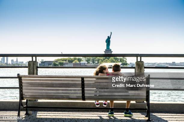 twee kinderen kijken naar vrijheidsbeeld - liberty eiland stockfoto's en -beelden
