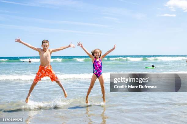 kids jumping in the air at the beach - new jersey shore stock pictures, royalty-free photos & images