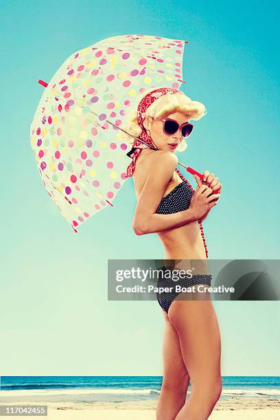 pin up pose of a young woman and her umbrella - vintage 1950s woman stock pictures, royalty-free photos & images