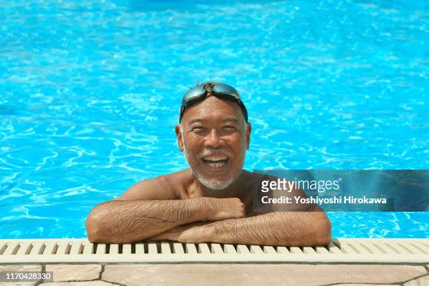 smiling senior man on the rooftop pool - rooftop pool stock-fotos und bilder