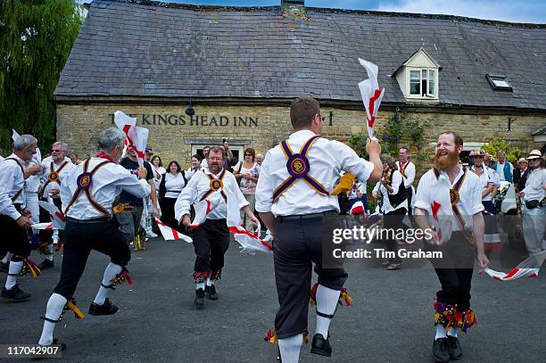 Morris dancers, Brighton Morris Men, perform a dancing display at The Kings Head Pub in Bledington, Oxfordshire, UK