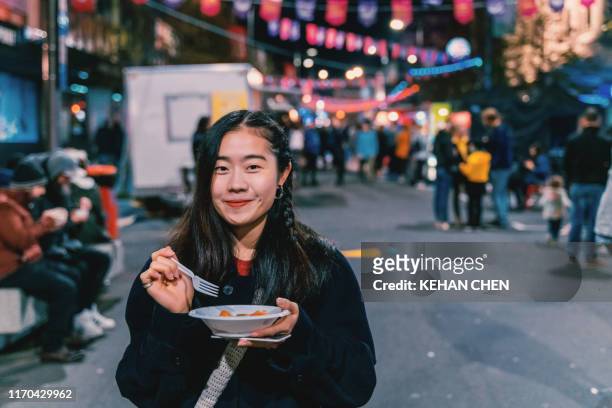 asian female eat food on the street - food street market stock pictures, royalty-free photos & images