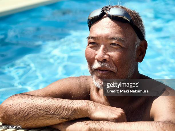senior man relaxing on pool edge - first gray hair stock pictures, royalty-free photos & images