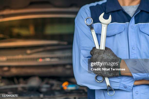 professional mechanic in the garage. auto repair garage. hands of car mechanic with wrench in garage. - sleutel handgereedschap stockfoto's en -beelden