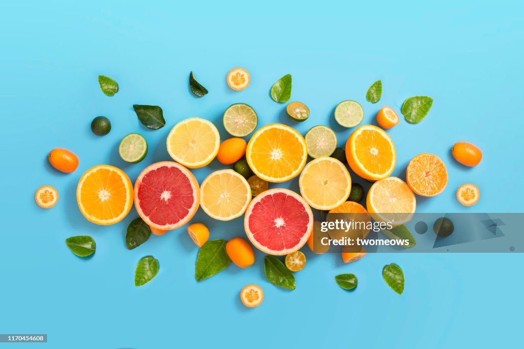Various citrus fruits on blue background.