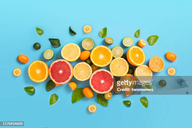 various citrus fruits on blue background. - ascorbic acid stock pictures, royalty-free photos & images
