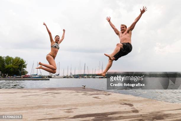 taking the plunge: young adults jump into wannsee lake - do it stock pictures, royalty-free photos & images