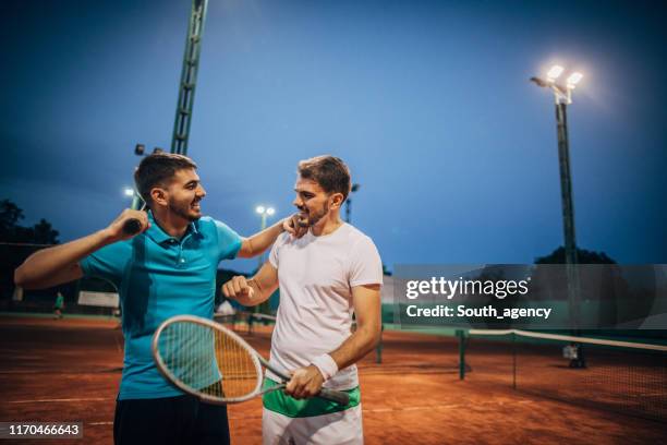 freunde tennisspieler nach einem spiel auf dem platz - doubles tennis stock-fotos und bilder