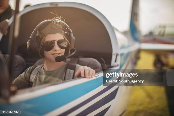 little girl sitting in propeller airplane - child pilot stock pictures, royalty-free photos & images