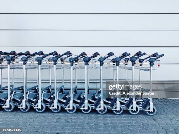 interlocked luggage carts at the airport terminal - chariot wheel photos et images de collection