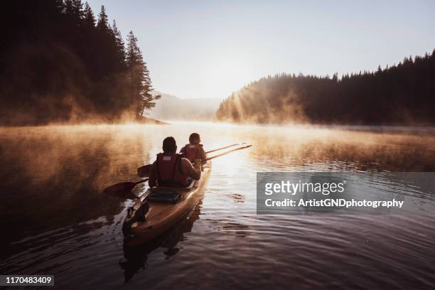 kajakfahren auf dem bergsee. - canoe stock-fotos und bilder