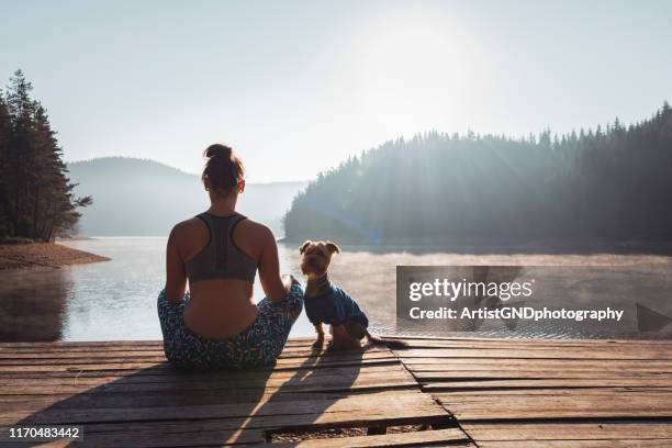 donna che pratica yoga al lago selvaggio. - meditation sitting foto e immagini stock