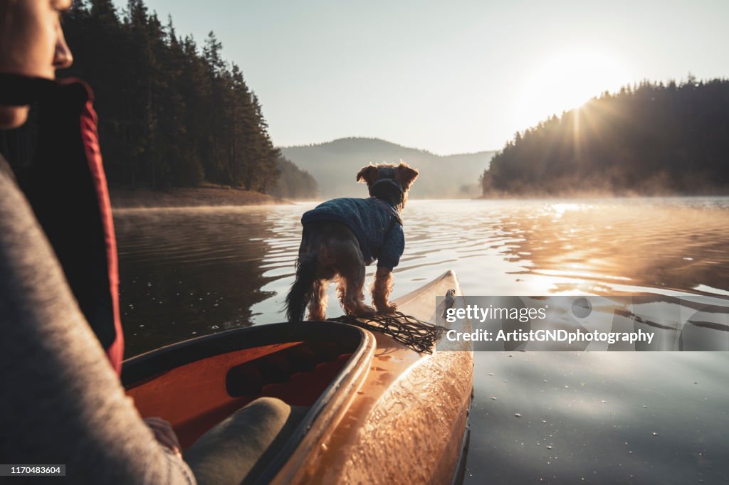 Rear view of woman and her dog on the edge of kayak