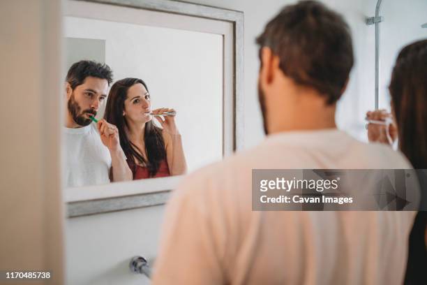 young couple brushing teeth in the bathroom - couples showering 個照片��及圖片檔