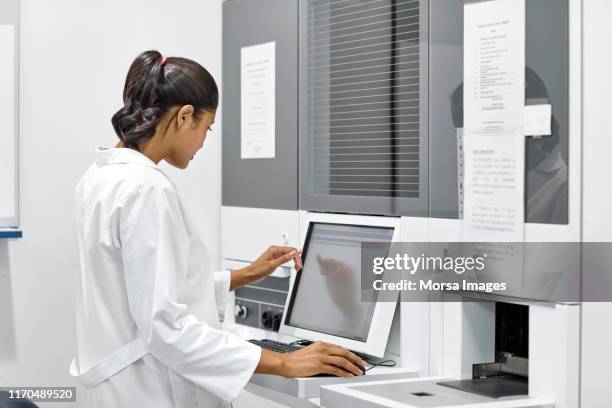 Pharmacist Using A Computer Young Pharmacist Using Computer In Laboratory High-Res Stock Photo ...