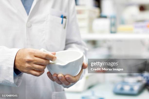 midsection of male pharmacist preparing medicine - homeopathie stockfoto's en -beelden