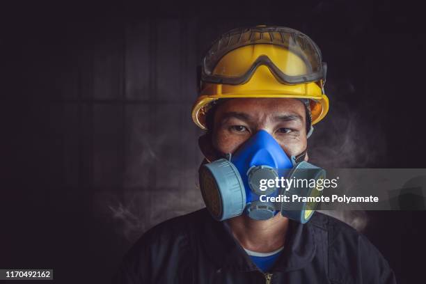 a rescue worker wears a respirator in a smokey, toxic atmosphere. image show the importance of protection readiness and safety in industrial factory. - air respirator mask stock pictures, royalty-free photos & images