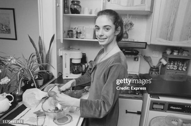 Italian prima ballerina Alessandra Ferri preparing food in a kitchen, UK, 21st May 1984.