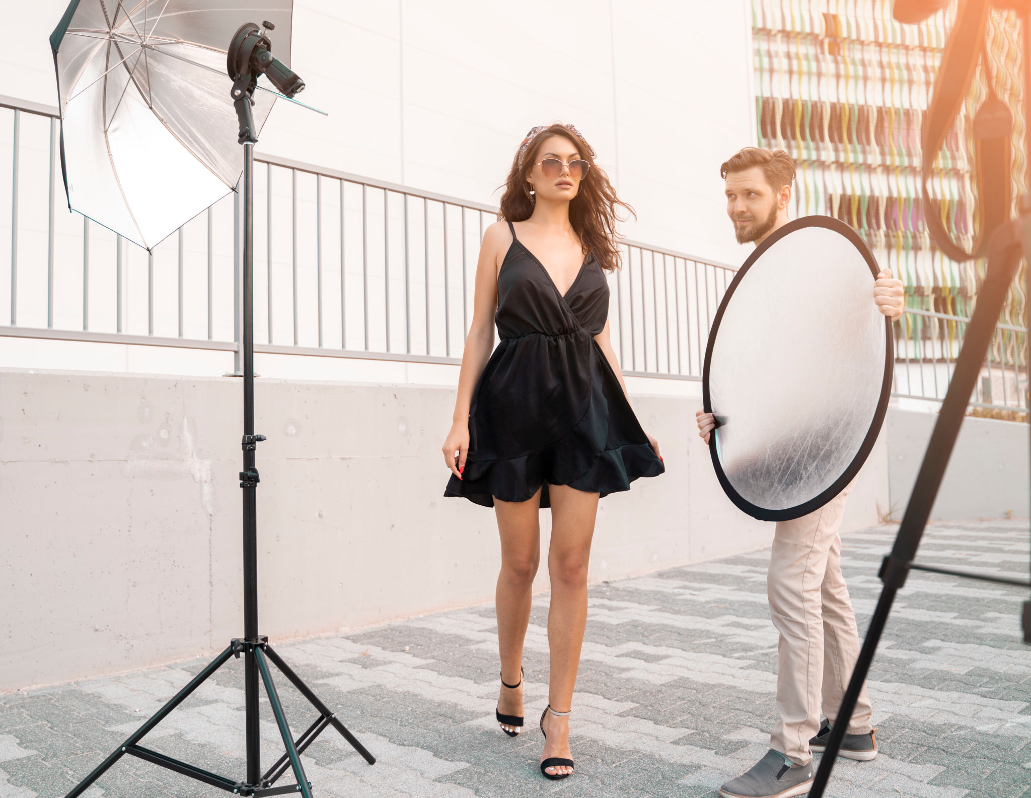 Attractive female fashion outdoors set, man assistent holding Attractive female fashion outdoors set, man assistent holding