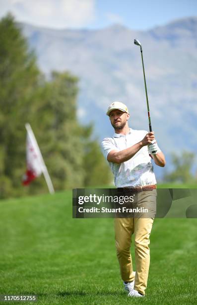 Musician Justin Timberlake plays a shot during practice prior to the start of the Omega European Masters at Crans Montana Golf Club on August 27,...