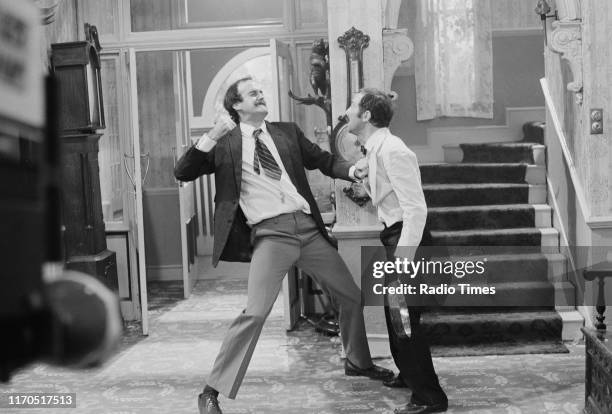 Actors John Cleese and Andrew Sachs filming a scene for episode 'The Germans' of the BBC television sitcom 'Fawlty Towers', August 31st 1975.