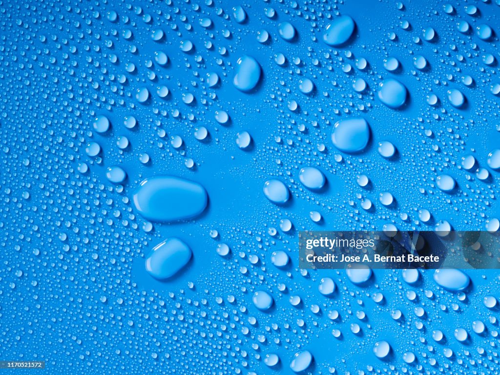 Full frame of the textures formed by the bubbles and drops of water, on a blue color background.