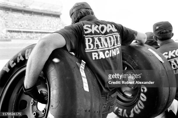 Crew members for NASCAR driver Harry Gant prepare to change Gant's tires during a pit stop at the 1983 Daytona 500 stock car race at Daytona...