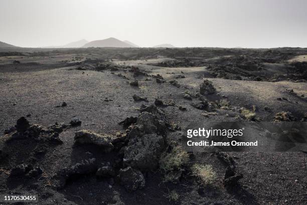 lava plain and distant volcanoes. - volcanic landscape fotografías e imágenes de stock