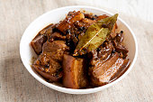 Homemade Filipino Adobo Pork in a bowl, side view. Close-up.