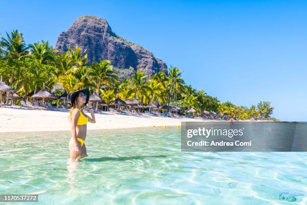 a tourist enjoys the sun in a tropical beach - mauritius beach stock-fotos und bilder